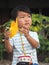 Asian lovely kid holding a yellow windmill toy with natural background.