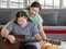 Asian lovely mother helping young chubby down syndrome autistic autism little daughter holding playing guitar in living room at