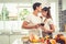 Asian lovers or couples kissing forehead and drinking wine in kitchen room at home. Love and happiness concept Sweet honeymoon