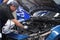 Asian male auto mechanic examine car engine breakdown problem in front of automotive vehicle car hood. Safety technical inspection