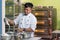 Asian male baker, pastry chef prepare dough with flour inside bakery kitchen