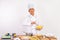 Asian male chef smiling while holding bowl and stirring