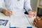 Asian male dentist hand holding pen writing patient history list on note pad and discussion about treatment plan