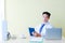 Asian male doctor with stethoscope looking at camera sat on the working chair hold a tablet on a desk in the hospital