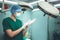 Asian male doctor Working in the operating room, wearing medical gloves to prepare for the surgical