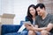 Asian male and female couples are looking for information on buying houses online on the website.