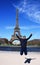 An Asian male jumping in front of Eiffel Tower