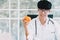 Asian male nutritionist holds an orange in his hand