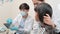 Asian male pediatric dentist explains teeth X-ray to a girl in a dental clinic.