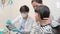 Asian male pediatric dentist explains teeth X-ray to a girl in a dental clinic.