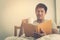 Asian male studying and drink coffee on morning bed