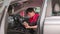 Asian male worker checking a maintenance list with tablet in a car interior.