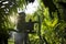 Asian man beekeeper in orange protection suit getting out a honeycomb from a beehive with bees swarming around in the fruit tree g