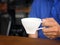 Asian man catch a glass to drink more coffee in coffee shop