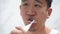 Asian man cleaning teeth using electric toothbrush