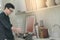 Asian man cooking with pot and ladle in kitchen