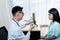 Asian man doctor showing a bottle of medicine to patients woman Who came to receive treatment at hospita