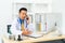 Asian man doctor writing document white talking to consulting patient by telephone or mobile phone. Telemedicine, telehealth