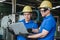 Asian man engineering learning work instructions holding laptop computer at factory.