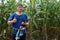 Asian man farmer wears blue shirt and holds smart tablet at maize garden.