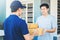 Asian Man hand accepting a delivery boxes from professional deliveryman at home