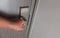 an asian man hand holding metal knob and trying to open door