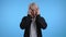 Asian man having headache, studio portrait. Korean stylish guy putting hands on head, isolated on blue background