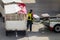 Asian man loader lifting up the luggage to conveyor belt of the trailer to loading passenger baggage to the airplane on the runway