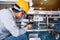 Asian man Mechanic technician worker working install and checking the electric control cabinet of conveyer in industrial factory