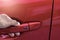 Asian man opens red car door with smart keyless For automotive or transportation image