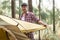 Asian man pitching tent while camping in forest