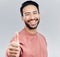 Asian man, portrait smile and thumbs up for success, good job or winning against a white studio background. Happy male