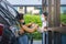 Asian man in protective mask taking food bag and coffee with woman waitress wearing face mask and face shield at drive thru during