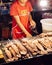 Asian man selling grill squids skewer at street food market Bang