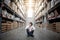 Asian man sitting between cardboard box shelves