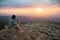 Asian man sitting on Nodule rock field enjoy looking sunset