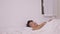 Asian man sleeping well in a comfy warm fresh bed on a soft pillow white linen orthopedic mattress, a calm serene male relaxing