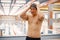 Asian man standing in indoors swimming pool and wearing a hat