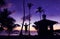 Asian man standing near the little hut on the coconut beach with a million stars and sunrise