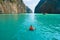 An Asian man, a tourist, diving, swimming or snorkeling in Krabi with blue turquoise seawater, Phuket island in summer season