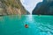 An Asian man, a tourist, diving, swimming or snorkeling in Krabi with blue turquoise seawater, Phuket island in summer season