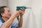 Asian man use electric drill on wall in him house, Home improvement and repairs concept, Copy space