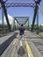 Asian man used crutches walks on The wooden bridge steel structure across the Pai River, Phitsanulok in Thailand