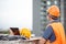 Asian man using drone and laptop for construction site survey