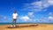 Asian man in white shirt and jeans, wearing sunglasses, stand on timber with sea, blue sky and cloud background with copy space