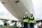 Asian man and woman engineer maintenance airplane arm crossed and holding wrench in front airplane from repairs, fixes,