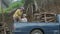 Asian man and woman fold down logs into pickup truck. Slow motion.