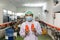 Asian man worker in sterile uniform showing product of bottled red juice in production line at beverage processing factory