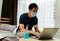 Asian Man working from home wearing protective mask in bedroom. Quarantine for coronavirus wearing protective mask at