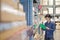 Asian manager man doing stocktaking of products management in cardboard box on shelves in warehouse using clipboard file and pen.